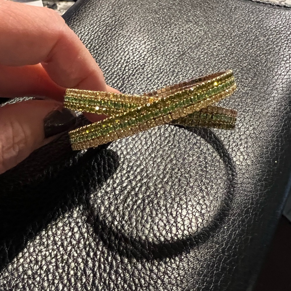 Gold tone cuff bracelet with green stones